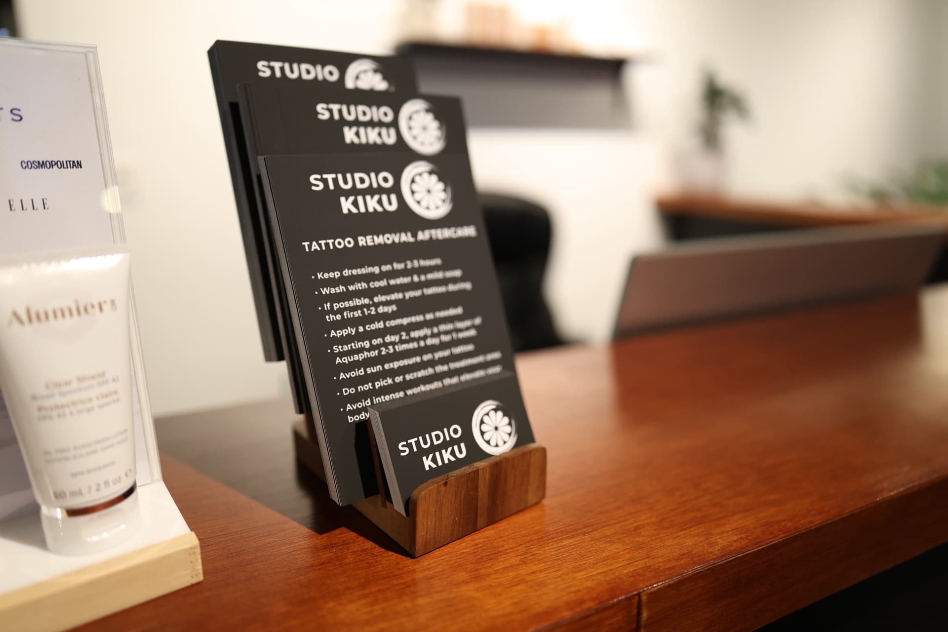 Studio Kiku aftercare instruction cards for laser tattoo removal laid out on a counter