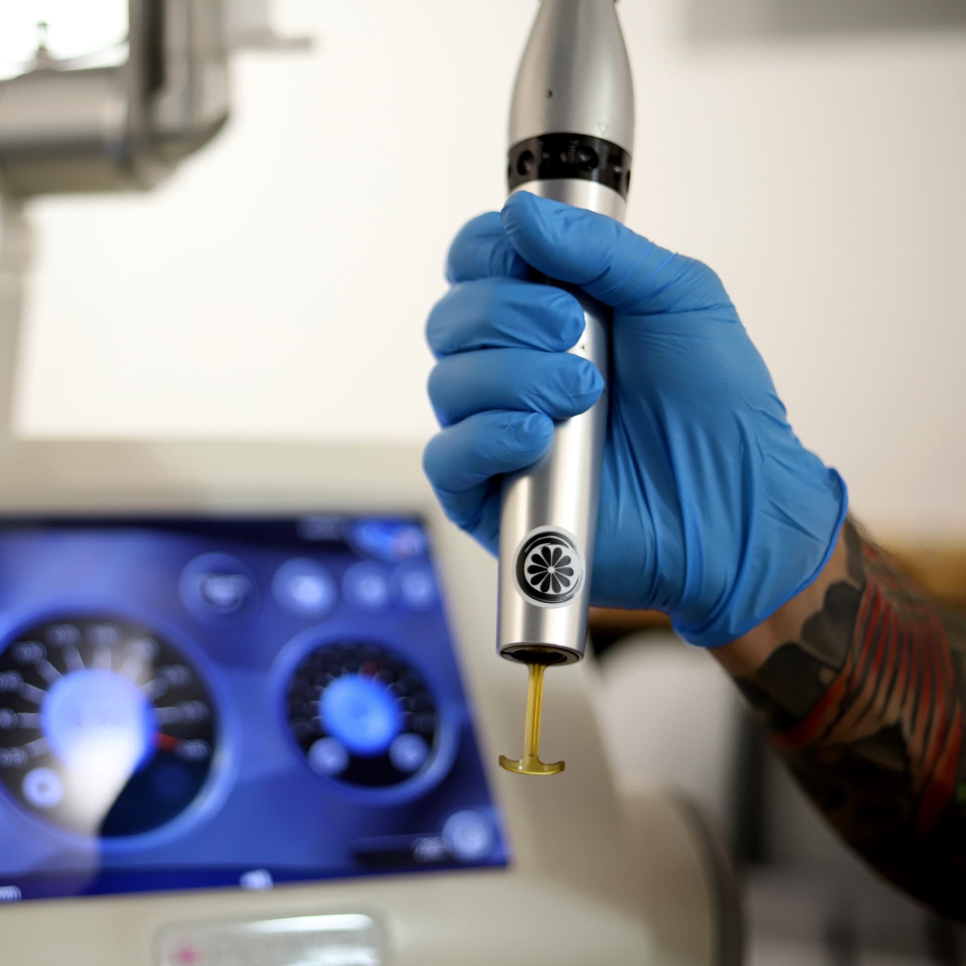 Studio Kiku branded laser handpiece held during a laser tattoo removal treatment